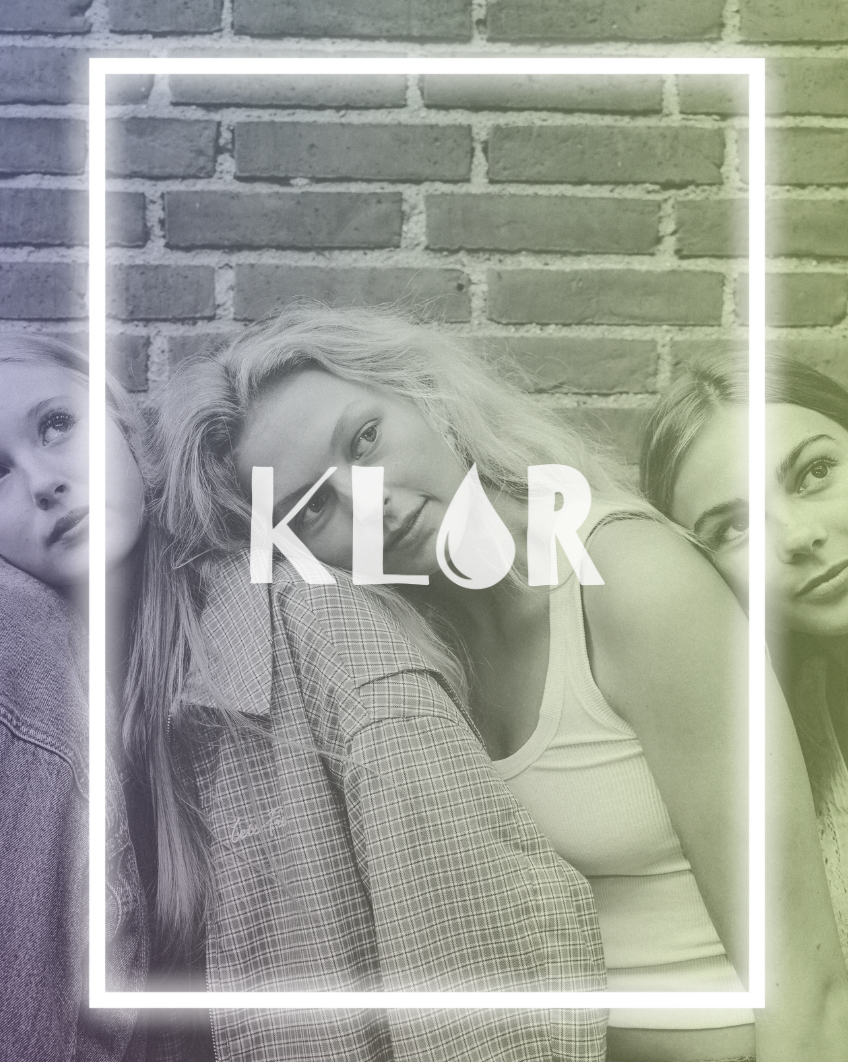 Three women leaning together in front of a brick wall with KLOR logo overlay